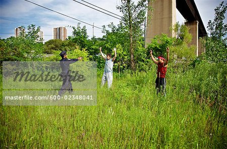 Police Officer Arresting Two Men in a Grassy Field