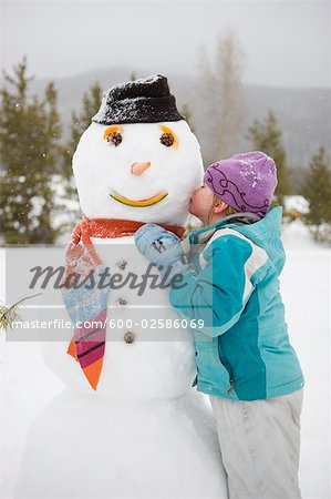 Girl Kissing Snowman, Near Frisco, Summit County, Colorado, USA