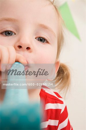 Little Girl Blowing a Noisemaker at a Birthday Party