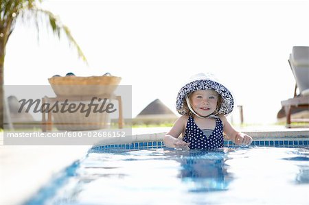 Girl Wearing Sunhat Standing in Swimming Pool, Cancun, Mexico