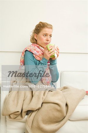 Woman holding Mug Sitting on Sofa
