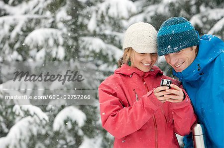 Close-up of Couple Using PDA Outdoors in Winter, Whistler, British Columbia, Canada