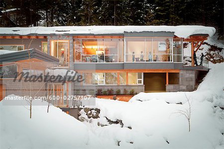 Exterior View of People inside Alpine Home in Winter, Whistler, British Columbia, Canada