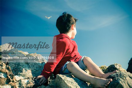 Little Boy Sitting on Rocks at the Beach, Harris Beach State Park, Brookings, Oregon, USA