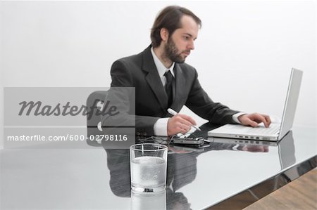 Tablets Dissolving in Glass of Water on Businessman's Desk