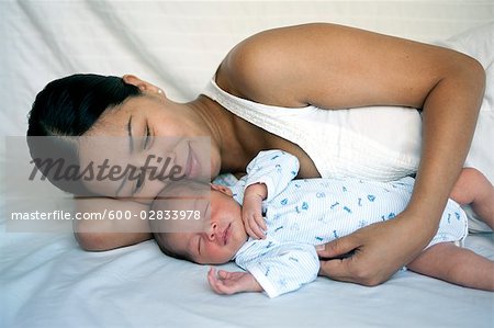 newborn baby sleeping with mom