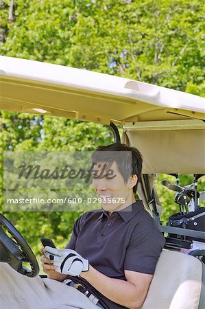 Man in Golf Cart Reading Text Message