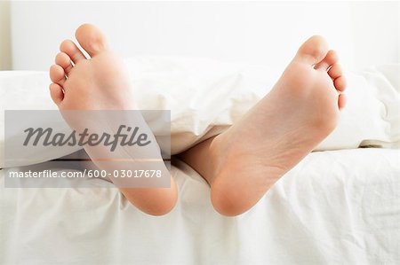 Close-up of Boy's Feet Hanging Off the End of the Bed