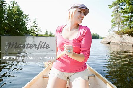 Woman Canoeing on Kahshe Lake, Muskoka, Ontario, Canada