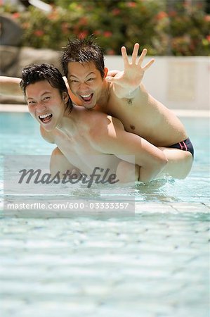 Male Couple Playing in Swimming Pool
