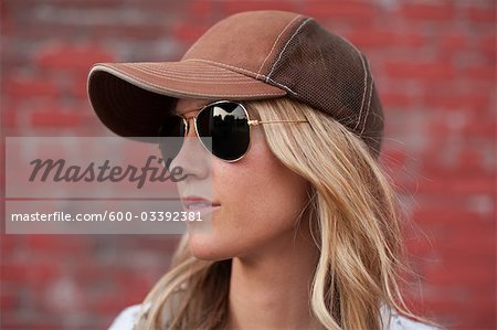 A woman wearing sunglasses standing in front of a wall photo