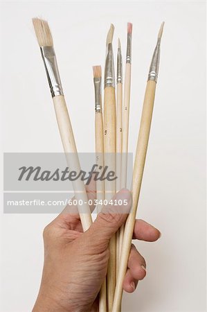 Person Holding Paintbrushes