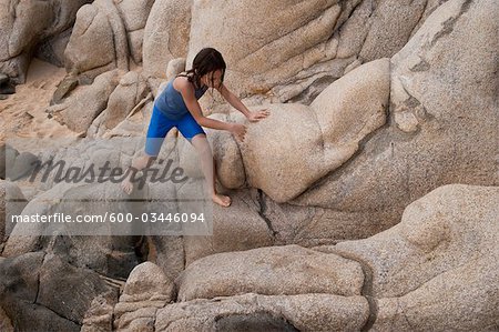 Girl Climbing Over Rocks