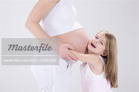 Little Girl Hugging Pregnant Mother