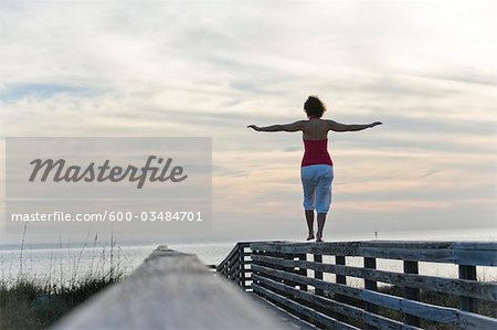 Woman Balancing on Wooden Railing, Honeymoon Island State Park, Florida, USA