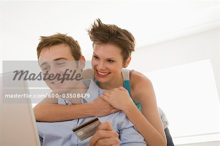 Young Couple with Credit Card and using Computer