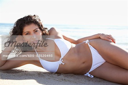 Portrait of Young Woman Lying on Beach, Zuma Beach, California, USA