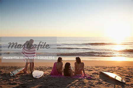 Backview of Young Women with Surfboards on Beach at Sunset, Zuma Beach, California, USA