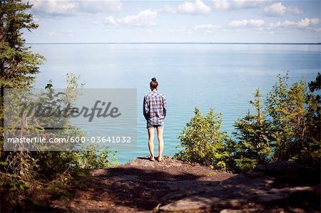 https://image1.masterfile.com/getImage/600-03641032em-woman-looking-out-at-clearwater-lake-clearwater-lake-provincial.jpg