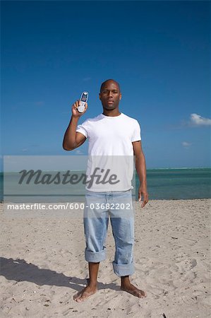 Man on the Beach Holding a Cell Phone, Florida, USA