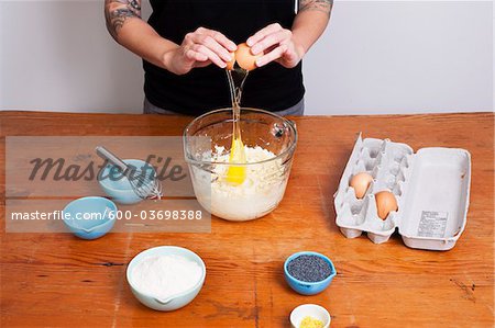 Woman Cracking an Egg Into a Bowl of Flour, Vancouver, British Columbia, Canada