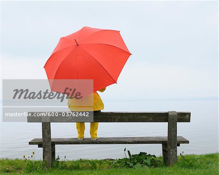 Women sitting on Bench with Umbrella, Lake Chiemsee, Bavaria, Germany