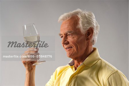 Man Looking at Wine in Glass
