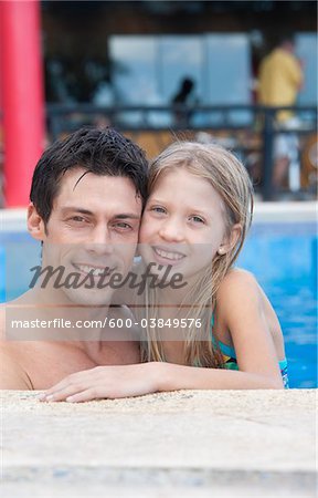 Close-up Portrait of Father and Daughter in Swimming Pool