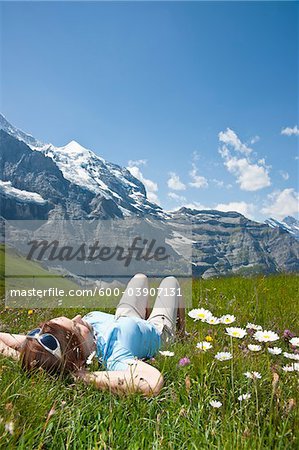 Woman Lying on Grass on Mountain Side, Bernese Oberland, Switzerland