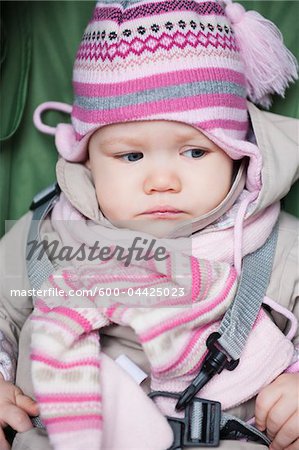 Close-up of Baby Girl Sitting in Car Seat wearing Winter Clothing