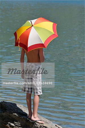 Back View of Boy using Umbrella in Sun, Alps, France