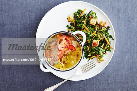 Overhead View of Salad and Casserole on Plate with Fork on Blue Background in Studio