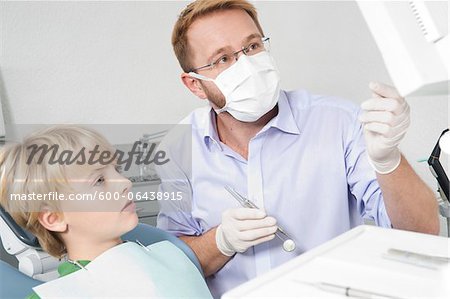 Boy and Dentist looking at Monitor during Appointment, Germany