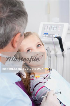 Girl looking up at Dentist during Appointment, Germany