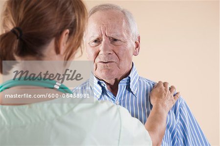 Senior Man being Examined by Medical Health Care Provider in Medical Office, Studio Shot on Beige Background