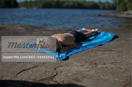 Young man on the rocks by the beach wearing underwear Stock Photo