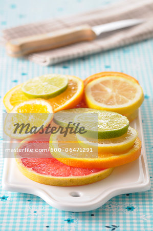Close-up of Slices of Citrus Fruits on Cutting Board on Blue Background