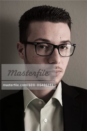 Head and Shoulder Portrait of Young Man wearing Glasses, Looking at Camera, Studio Shot