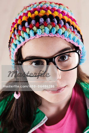 Close-up Portrait of Girl wearing Woolen Hat and Horn-rimmed Eyeglasses, Looking at Camera, Studio Shot on White Background