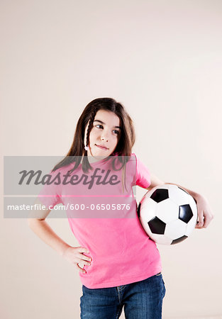 Portrait of Girl with Hand on Hips and Holding Soccer Ball, Looking to the Side, Studio Shot