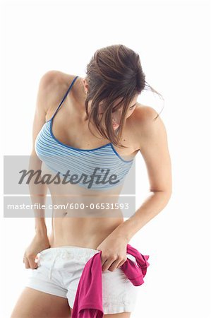 A pretty teenager girl in shorts and a sports bra, ready for running  running, isolated over white background Stock Photo - Alamy