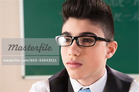 Close-up Portrait of Boy in front of Chalkboard in Classroom