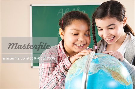 Portrait of Girls Looking at Globe in Classroom, Baden-Wurttemberg, Germany