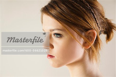 Close-up, Side View Portrait of Teenage Girl in Upsweep Hairstyle and wearing Make-up, Studio Shot on White Background