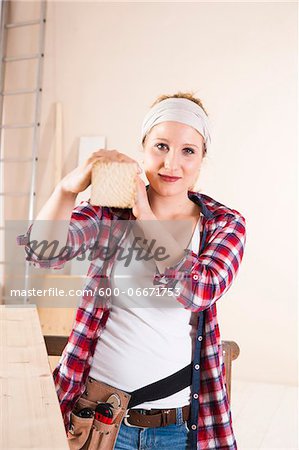 Studio Shot of Young Woman Carrying Lumber