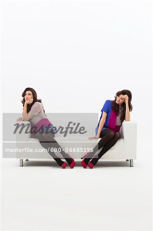 Multiple Image of Young Woman Sitting on Sofa, Studio Shot on White Background