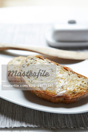 Close-up of Buttered Multigrain Toast with Wooden Knife, Studio Shot