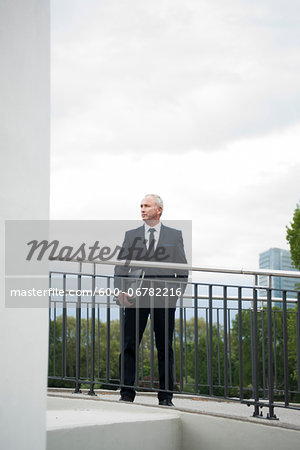 Mature businessman standing on bridge, Mannheim, Germany