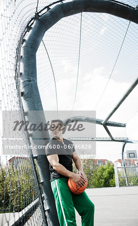 Mature man standing on outdoor outdoor basketball court, Germany