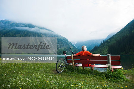 Mature Man on Bench by Lake with Mountain Bike, Vilsalpsee, Tannheim Valley, Tyrol, Austria